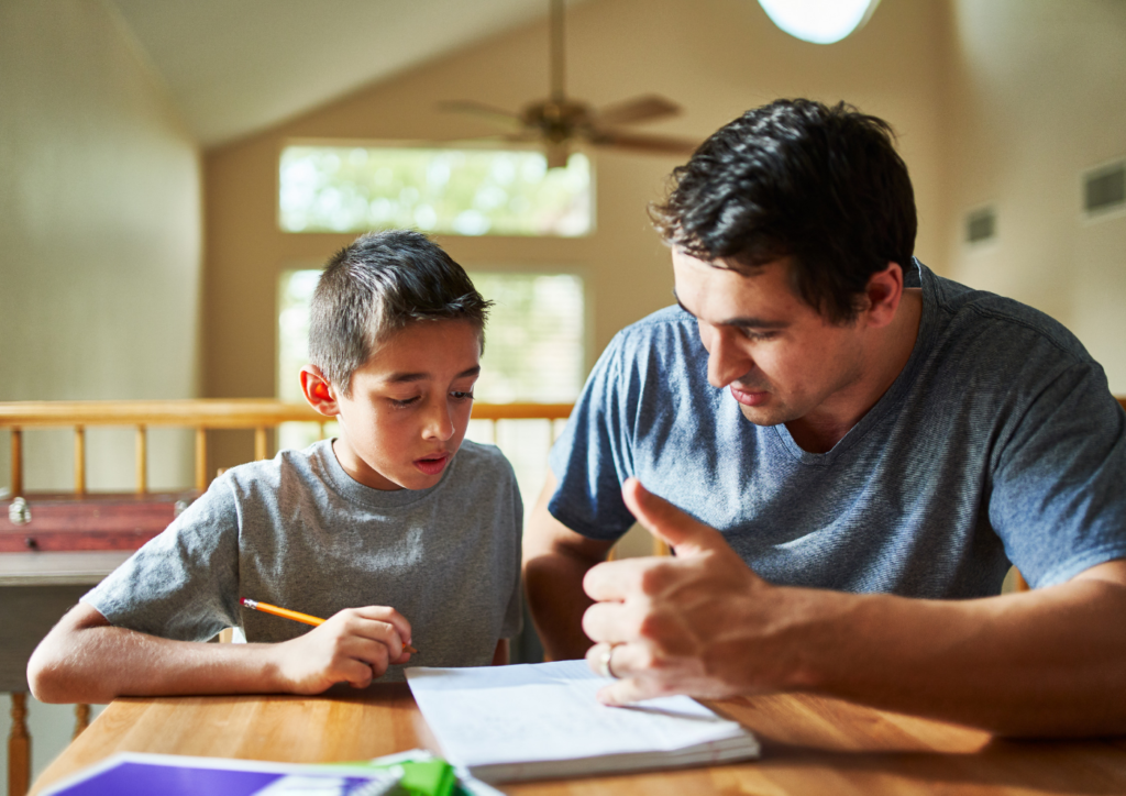 Father and son reviewing homework as part of their success plan